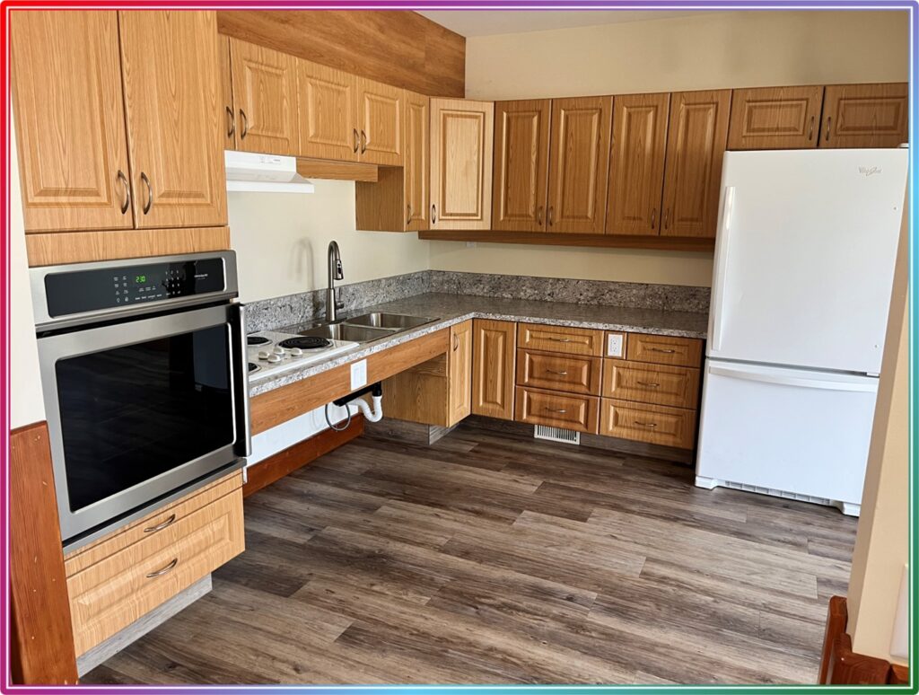 a kitchen with wooden cabinets, standard appliances, countertops and sink