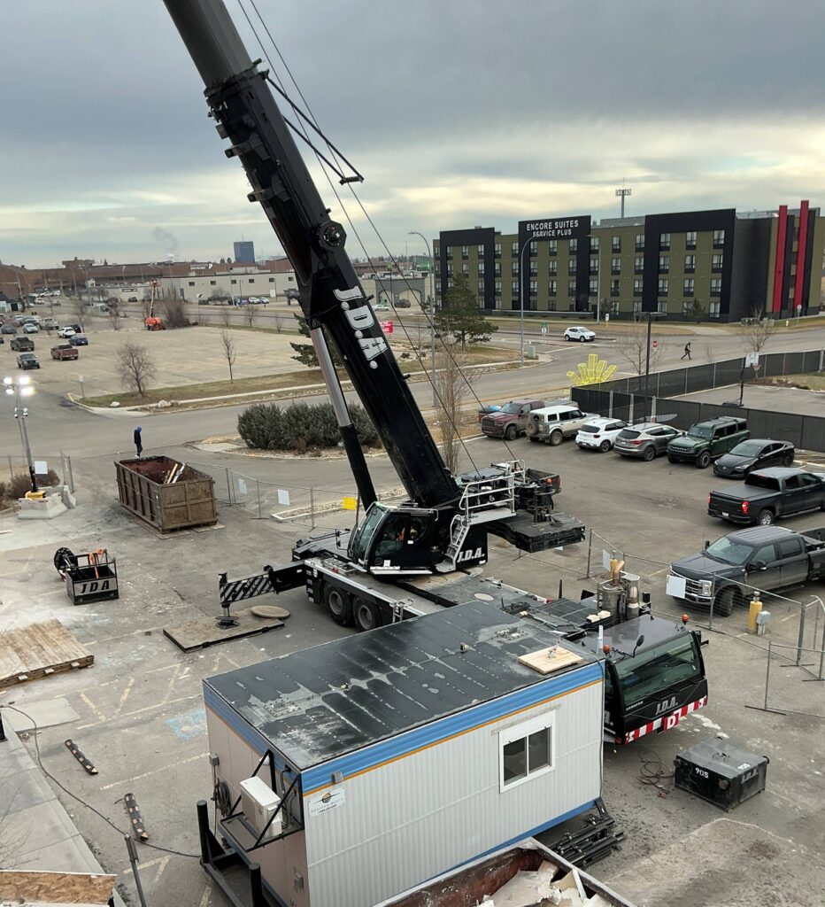 Crane operating beside temporary site offices at a construction are